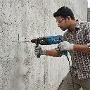 Indian_male_worker_drilling_wall_202605241444.webp