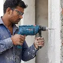 Man_drilling_masonry_wall_202605241455.webp